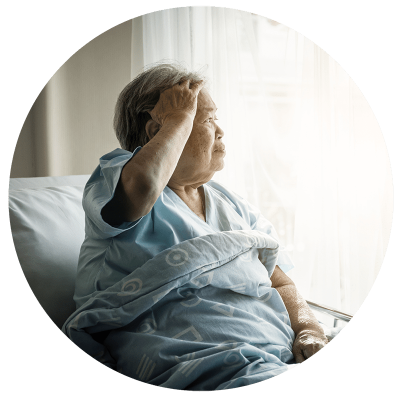 A patient sitting up a medical bed and looking out the window