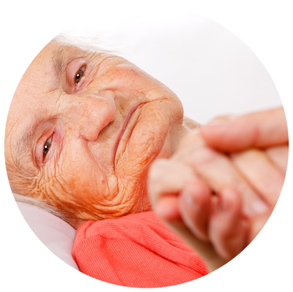 A senior patient holding hands with a caregiver