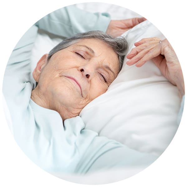 A senior woman sleeping in a hospital bed