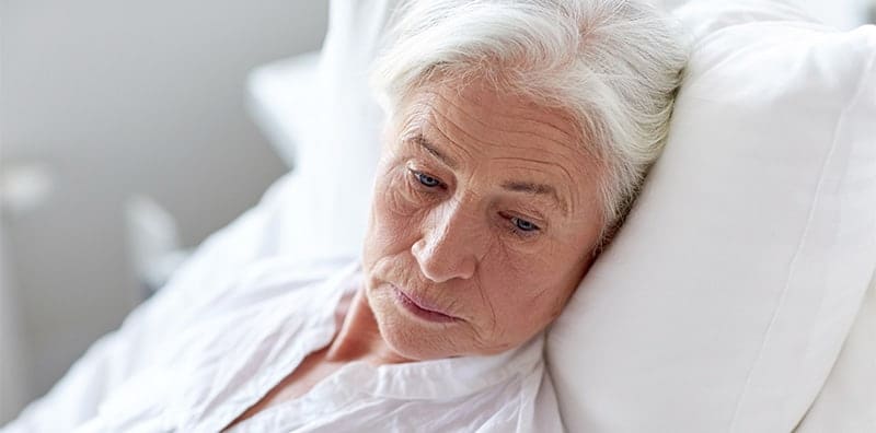 A senior patient in a hospital bed