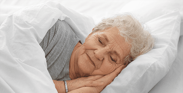 A senior woman sleeping soundly in a bed